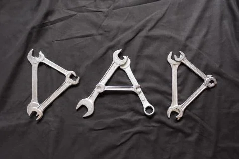Dad Written with Wrenches on a Black Background Stock Photos