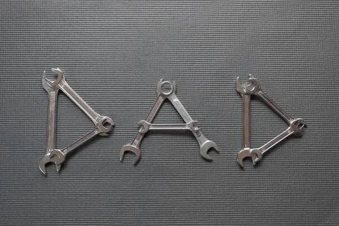 Dad Written with Wrenches on a Grey Background Stock Photos