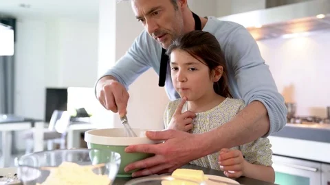 Daddy with daughter baking cake together in home kitchen Stock Footage 74114083