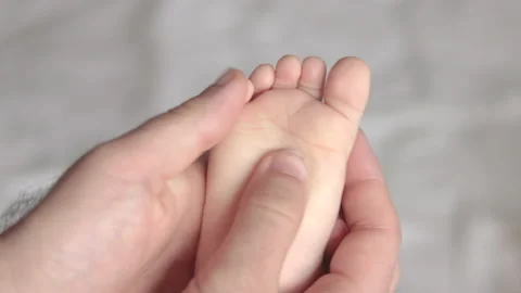 Daddy father hands massaging cute little baby infant new born feet Video stock 220867355