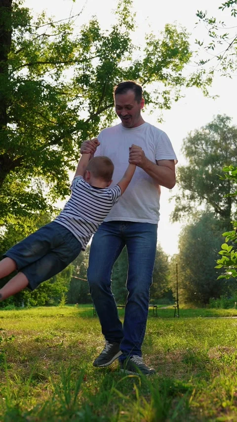 Daddy plays with his son on summer lawn in park. Happy family game in park Stock Footage 317916475