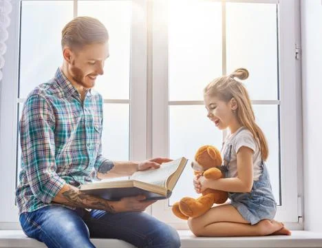 Daddy reading a book Stock Photos
