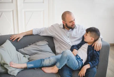 Daddy with son relaxing on sofa. Stock-Fotos