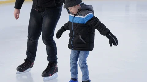Daddy teaches son how to ice skate next to each other feet close up Stock-Footage 85649460
