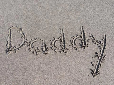 "daddy" is written on the sand Stock Photos