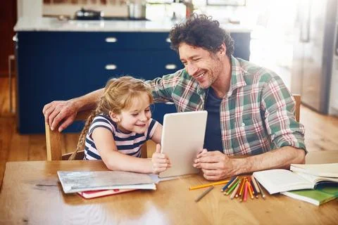 Dads giving her a lesson through the online world. a father helping his daughter Stock Photos