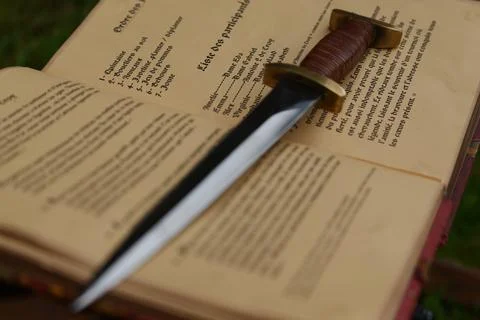 Dagger placed on a medieval book. Fotos de archivo