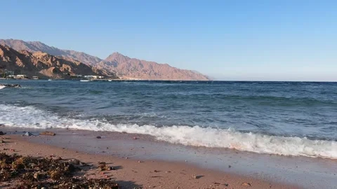 Dahab Beach with Waves Rolling onto Sandy Shore and Sinai Mountains in Stock Footage 341910365
