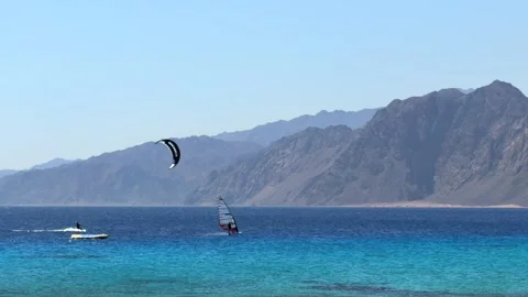 Dahab, Egypt - October 11, 2025: Kitesurfer and windsurfer with colored parafoil 스톡 동영상 340942567