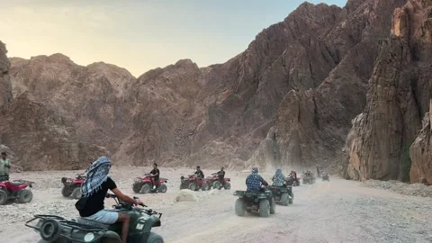 Dahab, Egypt - September 22, 2025: Group of tourists riding ATV through mountain Video stock 341838476