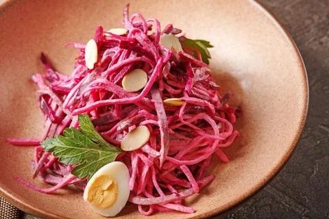 Daikon and beet salad dressed with mayonnaise or yogurt, garnished with almon Stock Photos