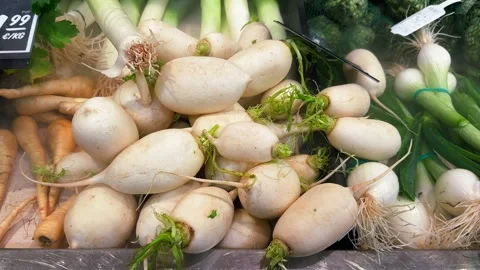 Daikon, a mild-flavored winter white radish at the food market. Stock Footage 329996595