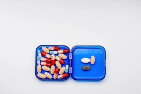 Daily boxes with different tablets and capsules lying on a white background Stock Photos