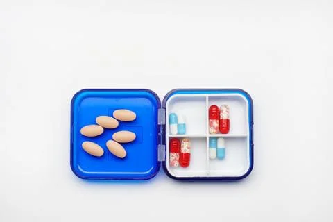 Daily boxes with different tablets and capsules lying on a white background Stock Photos