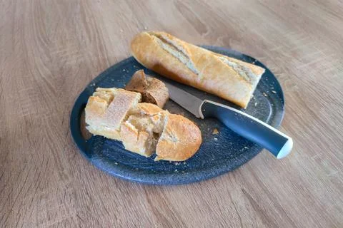 Daily bread with bread knife on a table Stock Photos