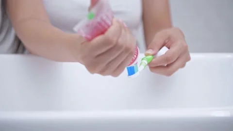 Daily routine concept of 4k Resolution. A young woman squeezing toothpaste on Stock Footage 147163068
