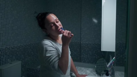 Daily Routine of a Woman Brushing Teeth in Bathroom Stock Footage 332249041