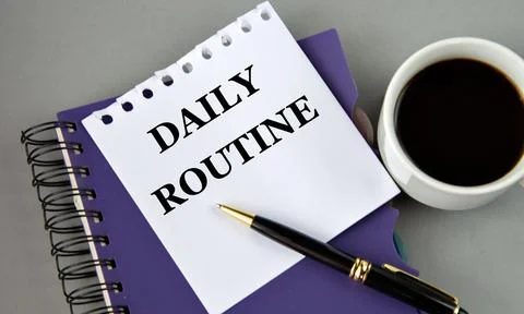 DAILY ROUTINE - words on a white sheet with a cup of coffee Stock Photos