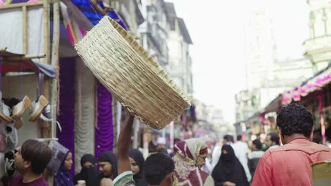 A Daily Wage Worker walking with a empty basket in one hand on a Market Street. Stock Footage 187959963