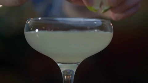 Daiquiri in a champagne saucer is decorated with a lime slice Stock Footage
