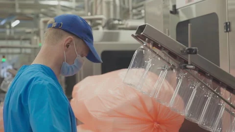Dairy Factory Worker Manually Attaches Bottles For Conveyor Production Stock Footage 172373862