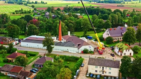 Dairy processing plant reconstruction with crane, and buildings in village in Stock Footage 334745547