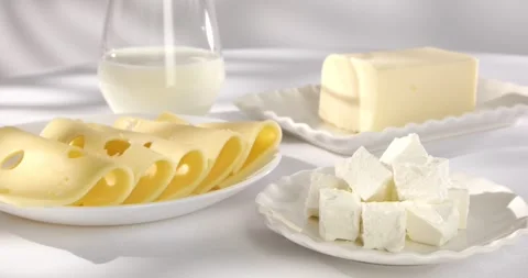 Dairy products on a light background. cheese and butter on white plates. Stock Footage 242447909