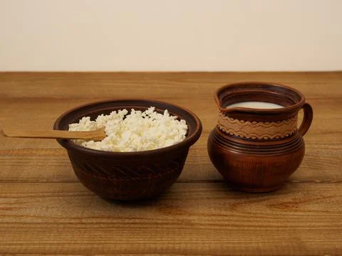 Dairy rustic products in an earthenware dish on a wooden table. Rustic simple Stock Photos