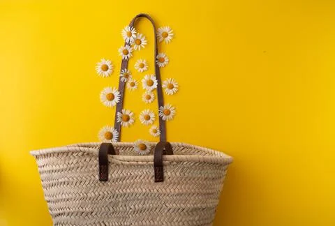 Daisies fall into a straw bag Stock Photos