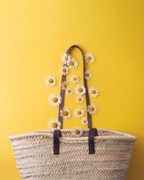 Daisies fall into a straw bag Stock Photos