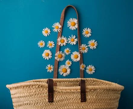 Daisies fall into a straw bag Stock Photos