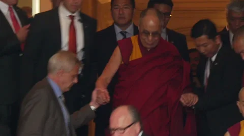Dalai Lama goes down stairs and is supported by companion Stock Footage