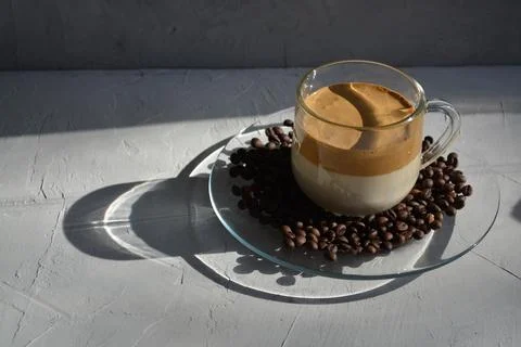 Dalgon coffee on a plate with coffee beans. It's a hard light. Horizontal image Stock Photos