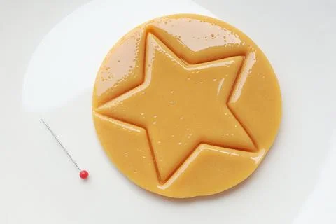 Dalgona candy or Ppopgi. Sugar Honeycomb cookie with star shape Stock Photos