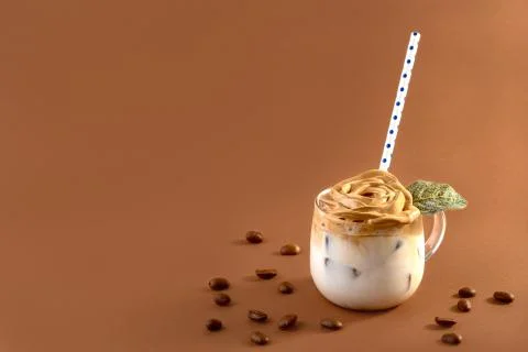 Dalgona coffee with foam in the shape of a rose. Stock Photos
