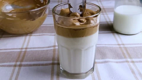 Dalgona coffee, whipped cold coffee with milk. Slow motion. Korean Kitchen Stock Footage 130738732