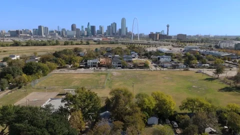 Dallas Skyline fly over gentrified homes under construction and soccer field Stock Footage 324773286