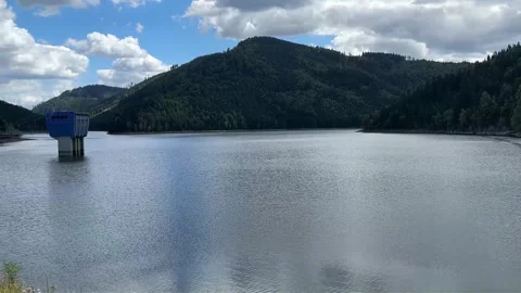 Dam and reservoir surrounded by forested mountains. Stock Footage 344308097