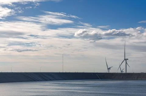 Dam and wind turbines under blue sky Stock Photos