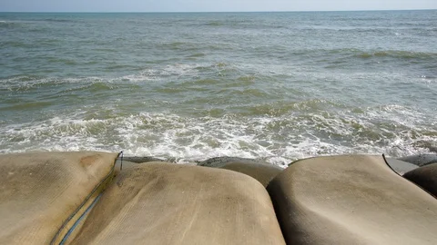 Dam impact wave by the Cha am sea and sand bag warning. Stock Footage 103576696