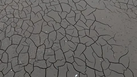 A dam stands at the end of a dried lake, with snow-covered ground and a dar.. Video stock 295764144
