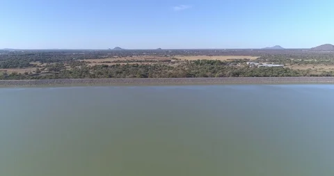 Dam wall seen from water side in the air with African landscape on the horizo Stock-Footage 95918424