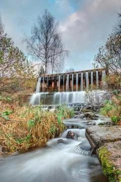 Dam with a waterfall on the river Stock Photos