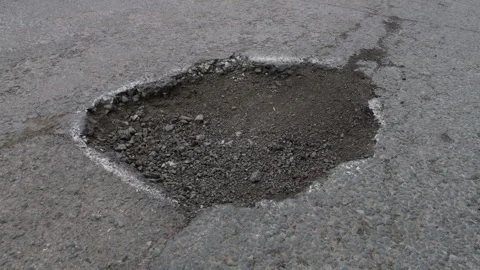 Damaged asphalt road with a large pothole Stock Footage 331303261