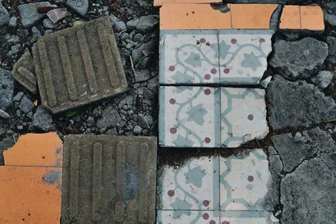 Damaged broken tile and a broken brick street pavement are on the ground. 写真素材