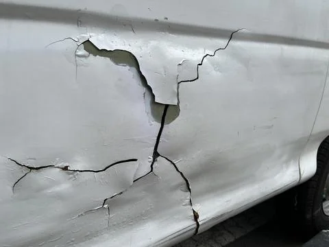 Damaged car because of accident with dent and cracked surface Stock Photos