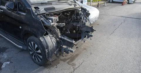 Damaged car with front end missing in a parking lot during daylight Foto stock