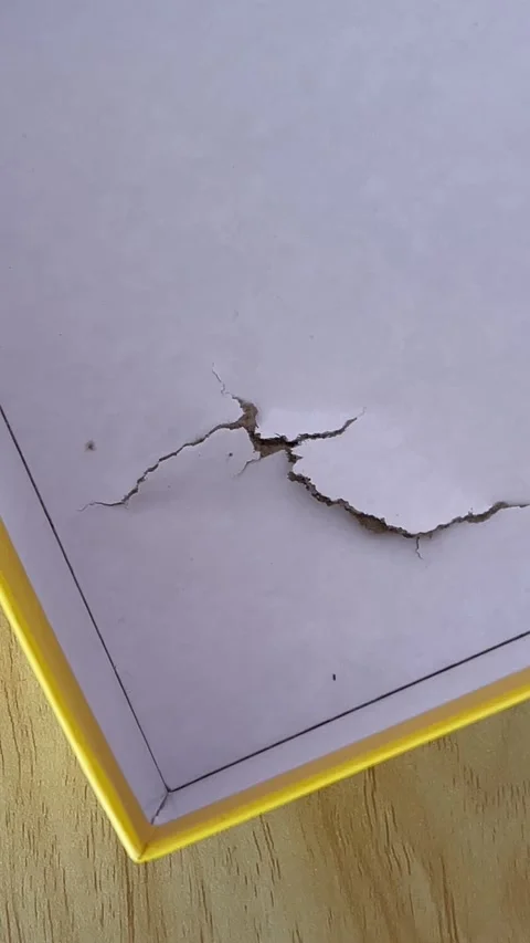 Damaged cardboard puzzle box showing shipping impact and packaging dents Stock Footage 320339904