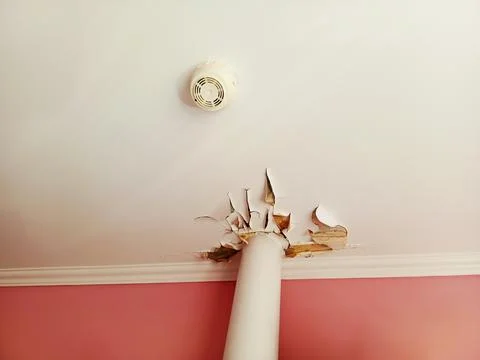 Damaged ceiling in the kitchen with cracked and peeling white paint on painte Stock Photos
