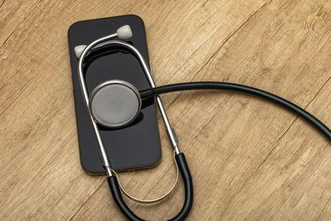 A damaged cell phone with a black screen turned off is placed on a wooden s.. Stock Photos